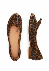 Ballerines en imprimé léopard avec un matériau en suède doux, bout rond et détail en nœud. Talon plat avec une semelle intérieure lisse couleur tan. Schéma de couleurs brun et noir.