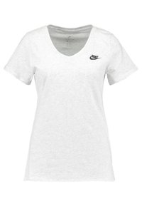 Camiseta blanca de manga corta con cuello en V, hecha de una tela suave, que presenta un pequeño logo negro de Nike en el lado izquierdo del pecho y un dobladillo ligeramente curvado.
