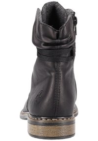 Bottine noire en cuir avec un design décontracté, doublure en textile gris, fermeture éclair et semelle cousue. Présente un logo discret sur le côté.