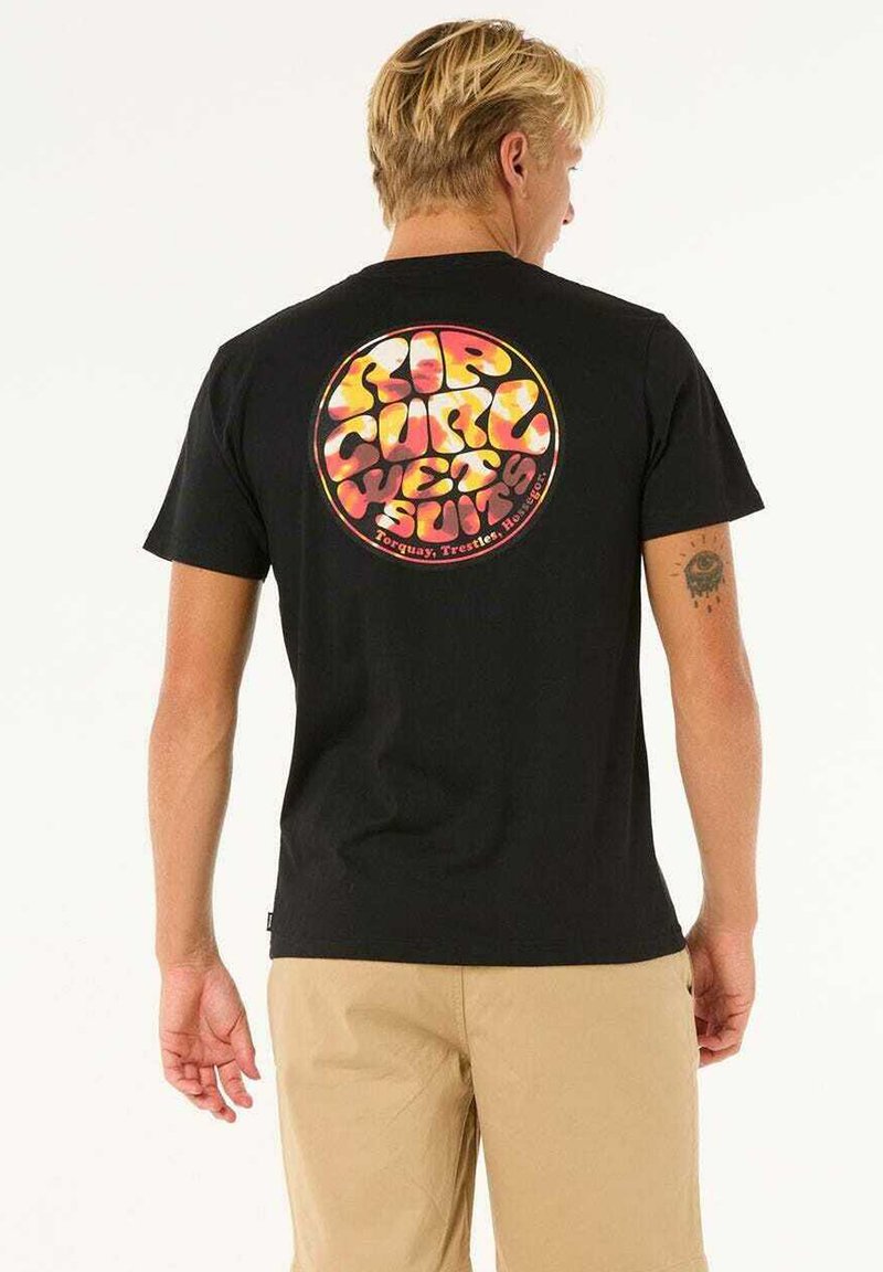 Camiseta de algodón negra con un gráfico circular colorido en la parte posterior que dice "RIP CURL WETSUITS", sobre un fondo liso.