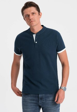 Navy niebieska koszulka polo z krótkim rękawem, z guzikowym kołnierzykiem Henley, kontrastowymi białymi akcentami na rękawach, teksturowanym materiałem i dopasowanym krojem.
