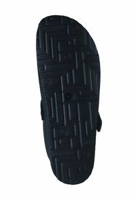 Black rubber sandal sole with textured geometric and circular patterns for grip and traction.