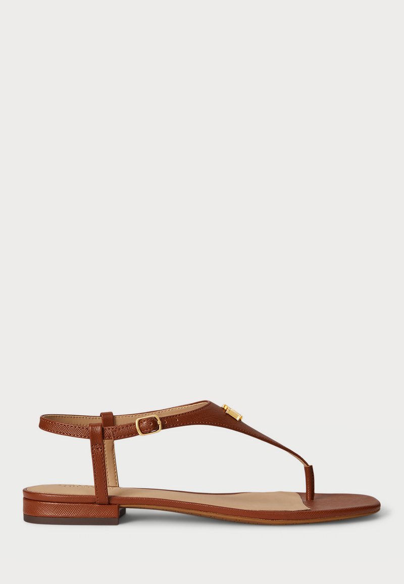 Sandal em couro castanho com design de tiras, correia ajustável no tornozelo, sola plana e um detalhe dourado na tira.
