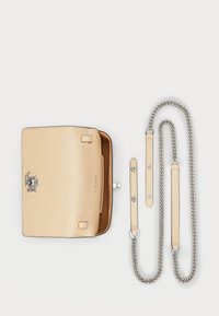 Beige textured leather handbag with a top flap, silver hardware, and a detachable chain strap. Features a lined interior and logo detail.