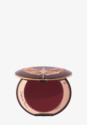 Poudre compacte de maquillage d'une teinte rouge profond, étui noir et or rose, embossé d'ailes stylisées et portant le nom Charlotte Tilbury.