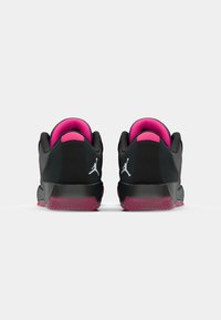 Schwarze Sneaker mit pinken Akzenten, ausgestattet mit einem strukturierten Obermaterial, gepolstertem Kragen und rutschfester Sohle. Logo auf der Ferse angezeigt.