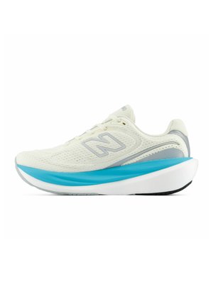 Biały i jasnoszary but do biegania z niebieską miękką podeszwą i białą podeszwą zewnętrzną, z siateczkową cholewką i logo New Balance po boku.
