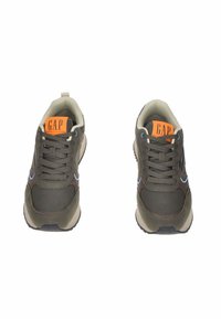 Sneaker verde scuro con accenti blu, design con lacci e logo GAP arancione sulla linguetta. Materiale morbido e suola in gomma per una buona aderenza.
