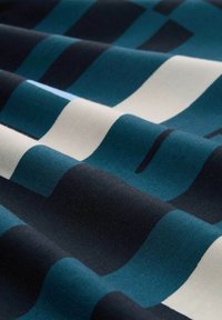 Geweven stof met een patroon van golvende lijnen in donker teal, zwart en crèmekleur. De textuur lijkt glad en licht glanzend.