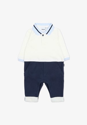 Ensemble deux pièces bleu marine comprenant un haut polo blanc avec des accents bleu clair, une fermeture à boutons, et un pantalon bleu marine avec des poches avant et des ourlets à revers.