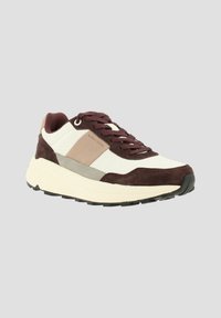Basket homme en marron, beige, blanc et gris avec une semelle blanche épaisse et un design à lacets, nom de la marque sur le panneau latéral.