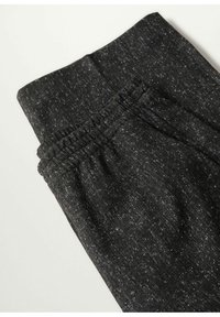 Zwarte sportbroek gemaakt van een gestructureerde stof met een gespikkeld patroon. Elastische tailleband, geen zichtbare hardware of zakken.