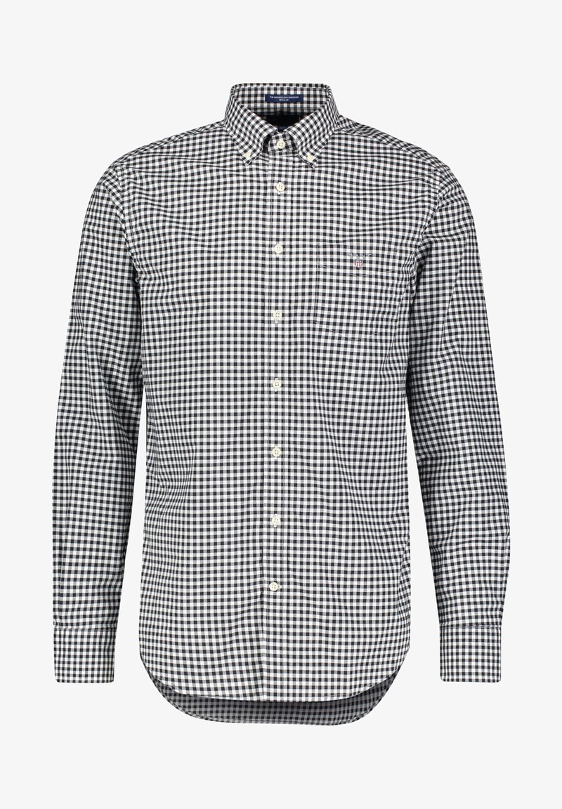 Chemise à manches longues à carreaux noirs et blancs, avec col boutonné et poche poitrine, sur fond blanc.