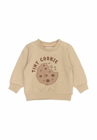 Béžová mikina se grafikou sušenky, která obsahuje akcenty tmavé čokolády a text "TINY COOKIE". Obsahuje kulatý výstřih a žebrované manžety.
