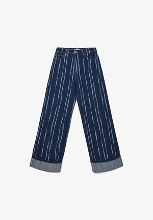 Jeans a gamba larga di colore blu scuro con strisce verticali chiare, orli arrotolati, tasche frontali, chiusura con bottone e zip.