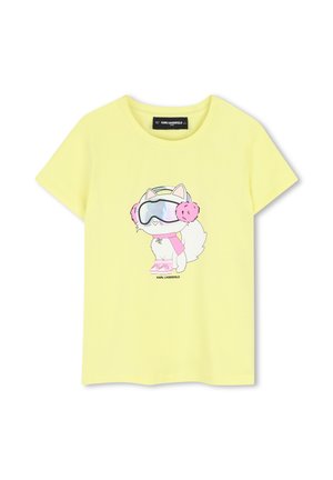 Gele korte mouwen T-shirt met een cartoon van een witte kat in het midden die roze oorwarmers, roze sjaal, roze laarzen en skibril draagt.