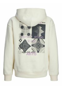Hooded sweatshirt in cream, featuring a patterned graphic in black and grey on the back, with “Originals STUDIO ARTS” in pink lettering.