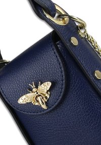 Marineblauwe leren handtas met een gestructureerde afwerking, voorzien van een gouden bijversiering, metalen beslag en een schouderriem met kettingdetails.