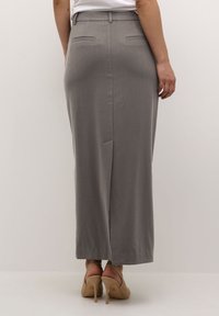Gray knee-length skirt made of smooth fabric, featuring a straight cut, two back pockets, and a two-slit design for ease of movement.