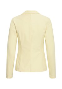 Blazer pour femmes de couleur crème avec manches longues, coupe ajustée et col cranté, vu de dos sur un fond blanc.