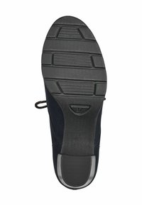 Semelle en caoutchouc noir avec un motif de grip texturé, dotée d'un bout arrondi et d'un petit talon. Boucle sur le côté pour faciliter l'enfilage. Taille indiquée comme 37.