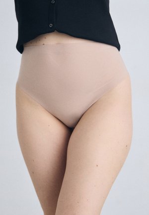 Beige høyhalsa truser laget av glatt, elastisk stoff, designet for komfort med en sømløs finish og et minimalistisk design.