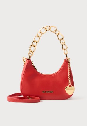 Punane Red Love Moschino käekott jämeda kullast kettakahvliga, eemaldatava rihmaga ja kullast südamekujulise ripatsiga valgel taustal.