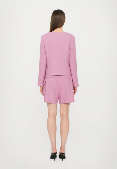 Pink tailored blazer and matching shorts set. The blazer features long sleeves, a round neckline, and a smooth texture.