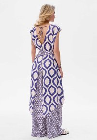 Fioletowa i kremowa sukienka w wzór z wiązaniem na plecach, krótkimi rękawami, asymetrycznym dołem oraz plecionym paskiem w geometryczny wzór.