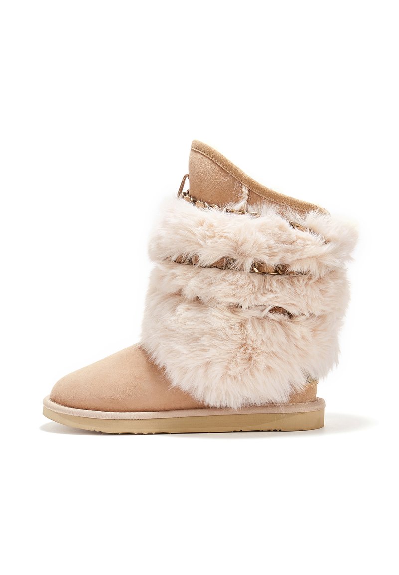 Bežové semišové čižmy s huňatým umelým kožúškom, zaoblenou špičkou, plochou podrážkou a dekoratívnymi prvkami na manžete. Mäkčený materiál po celom povrchu.