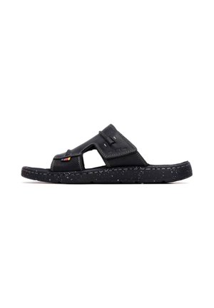 Sandali neri con una fascia testurizzata, lati aperti e suola screziata, caratterizzati da un piccolo motivo decorativo sulla parte superiore.