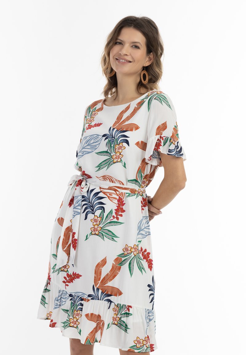 Bloemenjurk met een witte achtergrond, voorzien van groene bladeren, rode en oranje bloemen, korte gerimpelde mouwen en een strik taille.