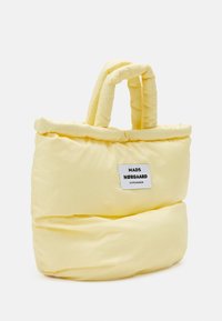 Gezwollen gele tote bag met twee korte handvatten, met een rechthoekige basis en een merketiket op de voorkant voor extra detail.