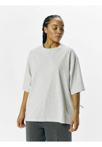 Grå oversized t-shirt lavet af blød bomuld, med rund halsudskæring, korte ærmer og en afslappet pasform. Ingen bemærkelsesværdige mønstre eller accenter.