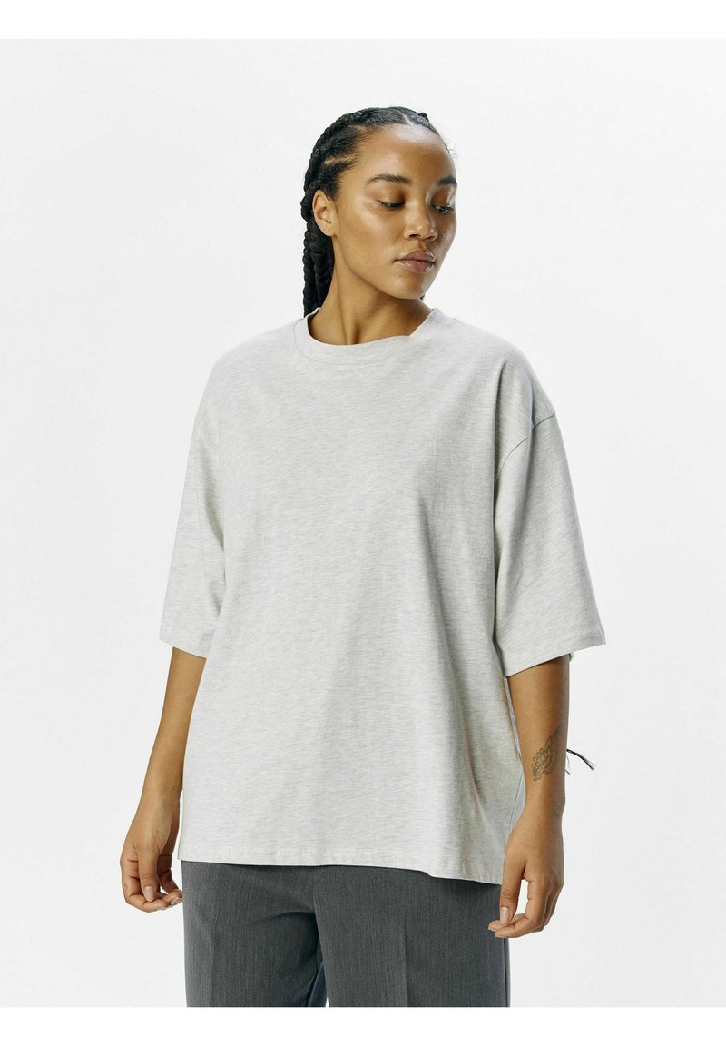 Grå oversized t-shirt lavet af blød bomuld, med rund halsudskæring, korte ærmer og en afslappet pasform. Ingen bemærkelsesværdige mønstre eller accenter.