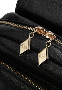 Zwarte leren rugzak met een gestructureerde oppervlakte, voorzien van een gouden rits en diamantvormige ritshendels met reliëfdetail.