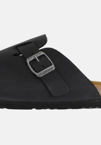 Zwarte sandaal met een brede band en een zilveren gespsluiting, kurken voetbed en een gegroefde rubberen zool. Minimalistisch ontwerp zonder aanvullende accenten.