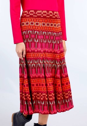 Knielanger Rock mit einem auffälligen geometrischen Muster in Pink, Rot und Brauntönen, fließendem Design und gefaltetem Textur.