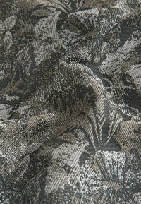 Textured fabric with a dark grey and beige pattern, featuring a floral design. Subtle sheen, woven texture with intricate detailing.
