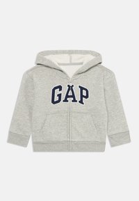 Felpa grigia con zip e cappuccio, logo "GAP" blu navy, tasche frontali doppie, polsini a coste e cappuccio. Interno morbido e design casual.
