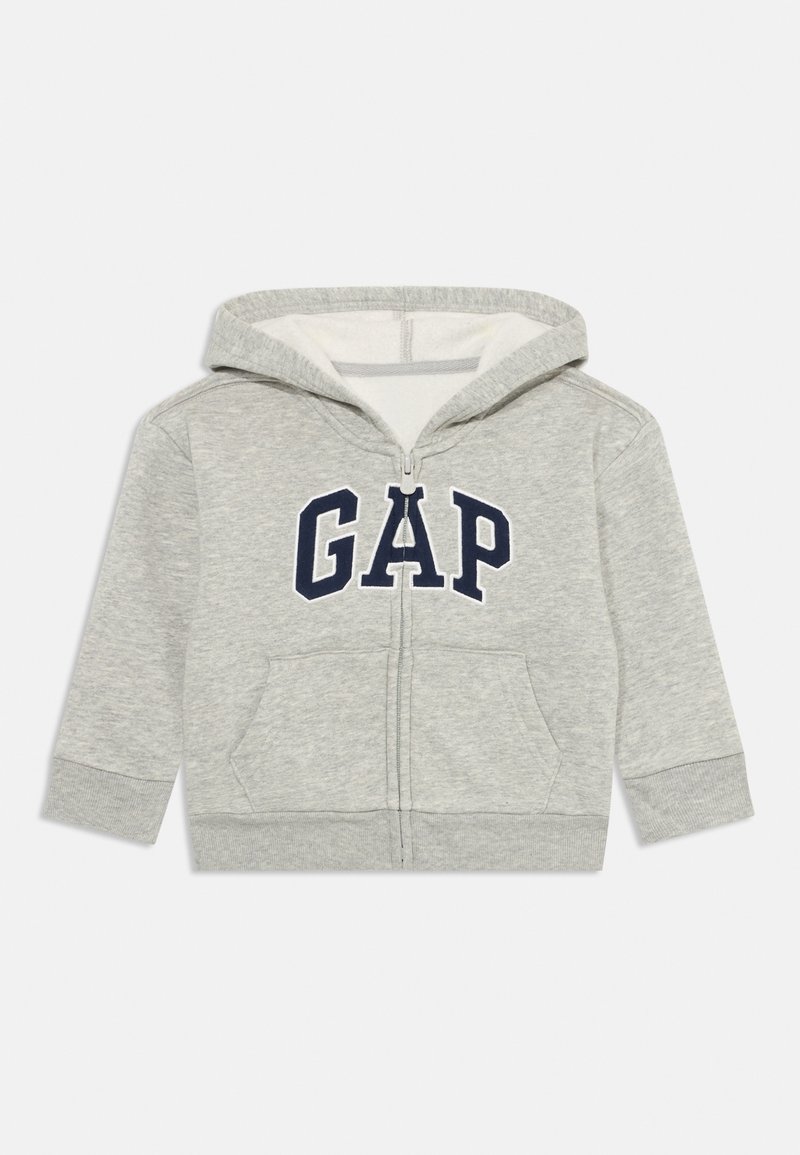 Felpa grigia con zip e cappuccio, logo "GAP" blu navy, tasche frontali doppie, polsini a coste e cappuccio. Interno morbido e design casual.