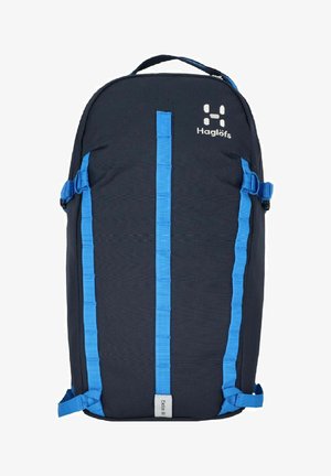 Mochila de color azul oscuro con correas azules, hecha de tela con un acabado texturizado. En la parte frontal presenta un logo y detalles de correas simétricos.