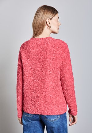Kastiger rosa Pullover aus flauschigem, strukturiertem Stoff, mit langen Ärmeln und Rundhalsausschnitt. Die Rückansicht zeigt eine lockere Passform.