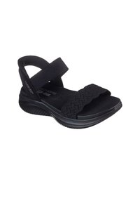 Sandalia negra con una banda elástica texturizada, correa de talón que brinda soporte y una suela acolchada. Diseño ligero, ideal para el uso casual.