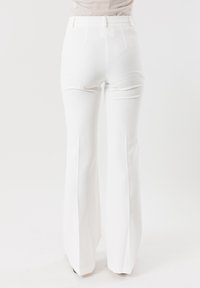 Pantaloni bianchi a campana con una finitura liscia, vita alta e pieghe frontali. Presentano un design semplice e gambe a taglio dritto per un look su misura.