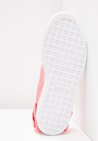 Różowe sneakersy z teksturowaną cholewką i białą gumową podeszwą, zdobione geometrycznym wzorem oraz wytłoczonym logotypem po boku.