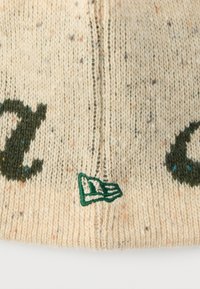 Cappello a maglia color crema con screziature colorate; presenta scritte verde scuro e un piccolo logo triangolare verde e bianco. Tessuto strutturato.