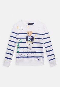 Camisa blanca de manga larga con rayas horizontales azul marino, que presenta un gráfico de un oso con una chaqueta azul y acentos de pintura salpicada.