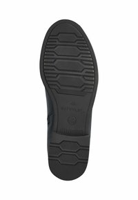 Suela de zapato de goma negra con patrón de tracción hexagonal y superficie texturizada. Presenta un logo en relieve y detalles de tamaño en el tacón.