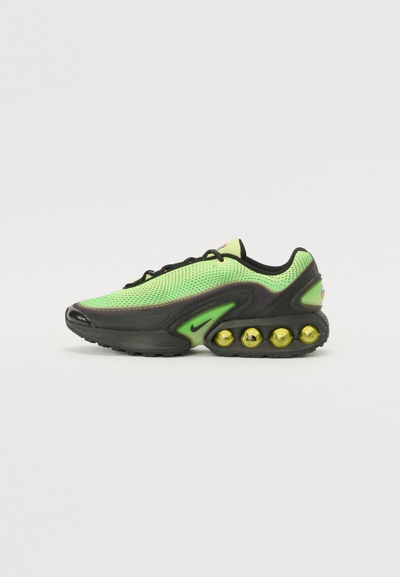 Nike sneakers featuring a mesh upper in bright green, black accents, and a distinctive sole with visible yellow air bubbles.